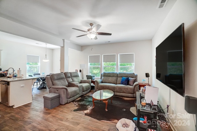 living room with ceiling fan, sink, wood-type flooring, and a healthy amount of sunlight