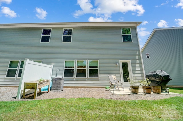 back of property featuring a patio area, central AC, and a yard