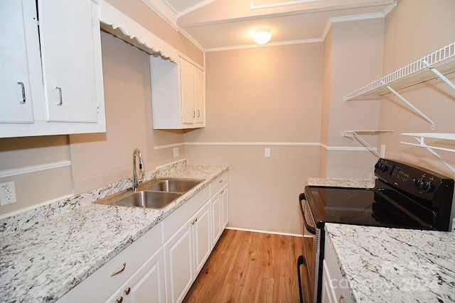 kitchen with sink, electric range, white cabinets, and crown molding