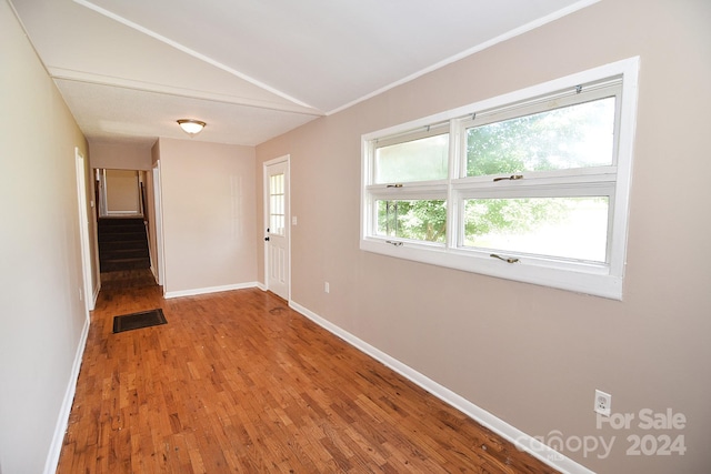 hallway with hardwood / wood-style flooring and lofted ceiling