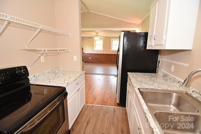 kitchen with stainless steel appliances, brick wall, white cabinets, light hardwood / wood-style flooring, and sink