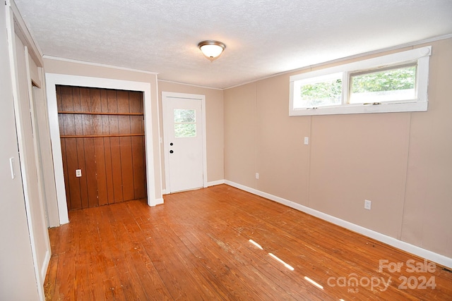 unfurnished bedroom featuring hardwood / wood-style flooring, a textured ceiling, and a closet