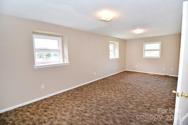 carpeted empty room with a textured ceiling