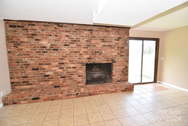 unfurnished living room with a textured ceiling, a brick fireplace, light tile patterned floors, and crown molding