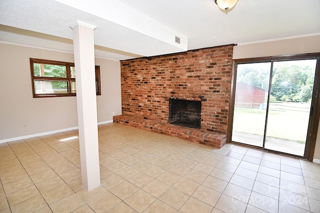 unfurnished living room featuring a textured ceiling, ornate columns, a brick fireplace, light tile patterned floors, and crown molding