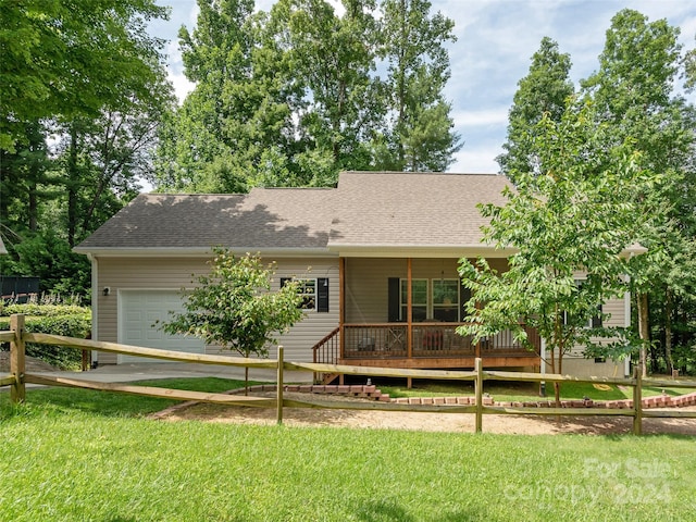 view of front of property featuring a front yard, a porch, and a garage