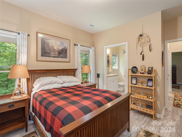 bedroom featuring hardwood / wood-style floors and ensuite bath