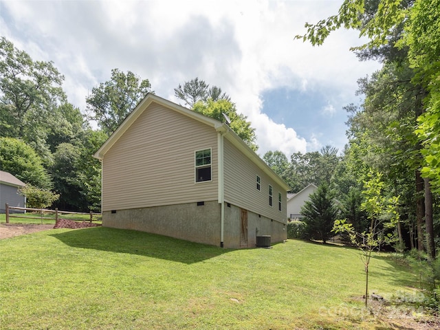 view of side of home featuring central AC and a lawn