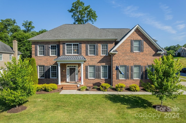 colonial inspired home with a front lawn