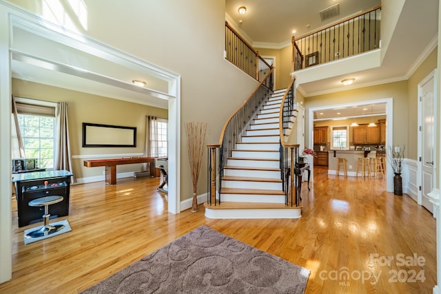 stairway featuring hardwood / wood-style floors and ornamental molding