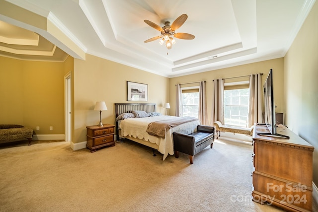 carpeted bedroom with a raised ceiling, ceiling fan, and crown molding