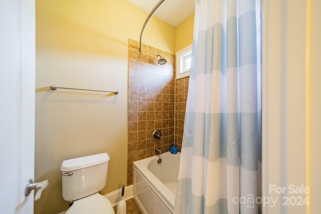 bathroom featuring shower / bath combination with curtain and toilet