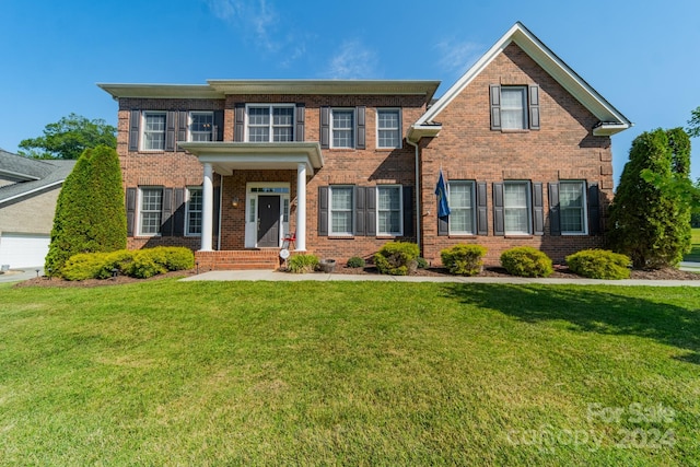 colonial inspired home with a front lawn