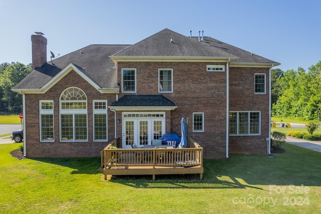 back of house featuring a lawn, a wooden deck, and french doors