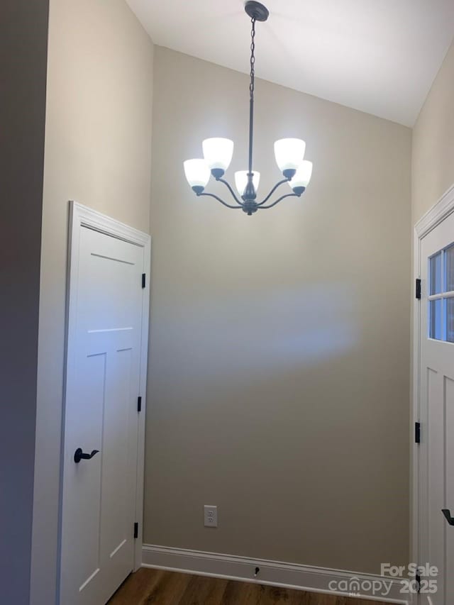 interior space featuring dark hardwood / wood-style floors and an inviting chandelier