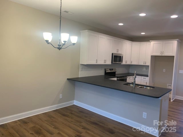 kitchen featuring kitchen peninsula, appliances with stainless steel finishes, sink, pendant lighting, and white cabinets