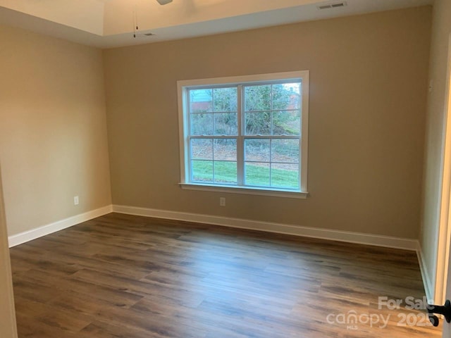 empty room with ceiling fan and dark wood-type flooring