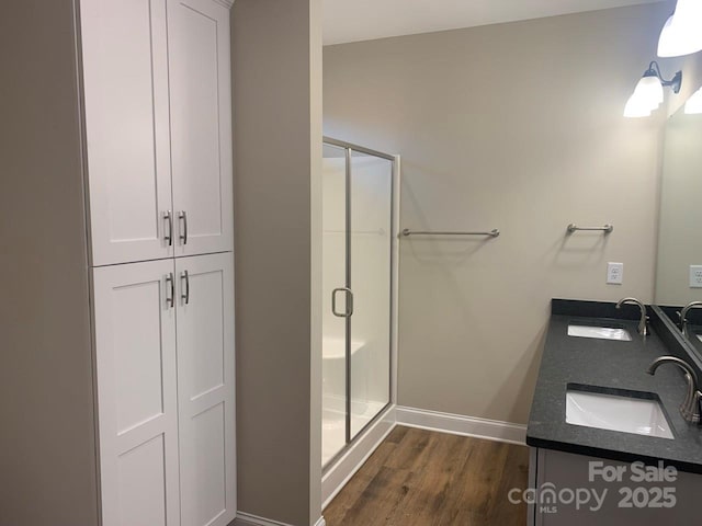 bathroom featuring hardwood / wood-style floors, vanity, and an enclosed shower