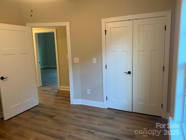 unfurnished bedroom featuring dark hardwood / wood-style floors and a closet