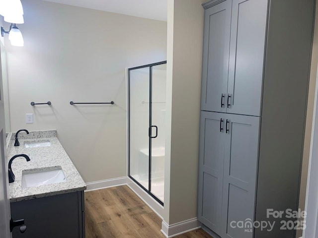 bathroom featuring a shower with door, vanity, and hardwood / wood-style flooring