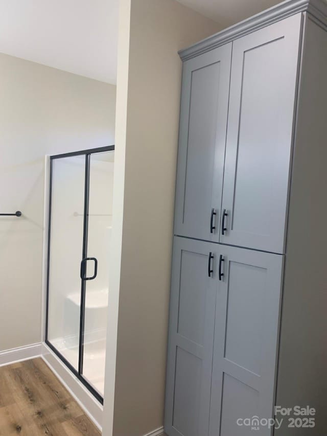 bathroom featuring a shower with door and hardwood / wood-style flooring