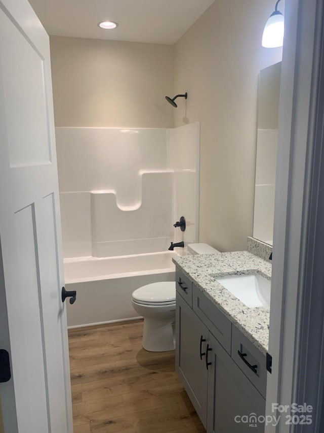 full bathroom featuring shower / washtub combination, toilet, vanity, and hardwood / wood-style flooring