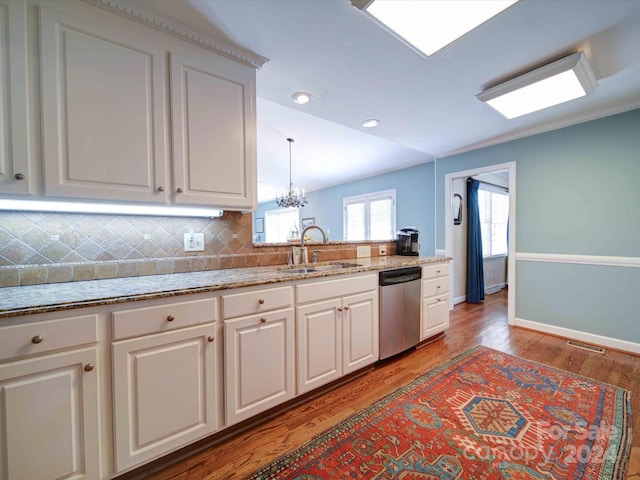 kitchen with white cabinetry, dishwasher, sink, hanging light fixtures, and wood-type flooring