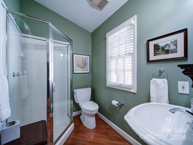 bathroom featuring wood-type flooring, toilet, walk in shower, and sink