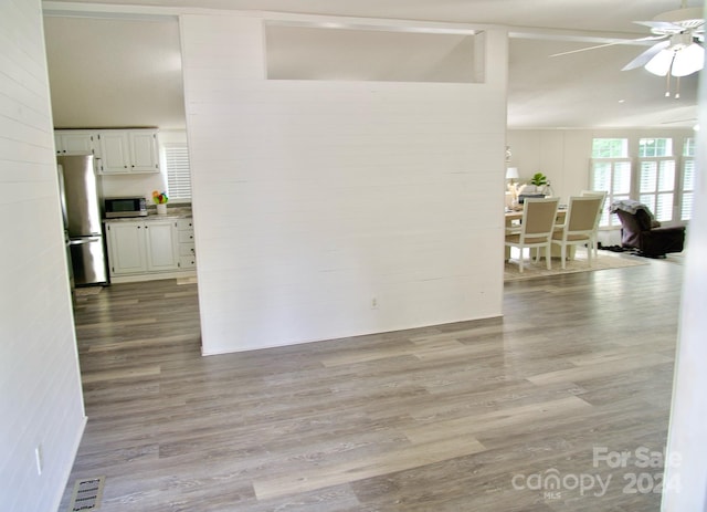 spare room featuring light wood-type flooring, ceiling fan, and lofted ceiling