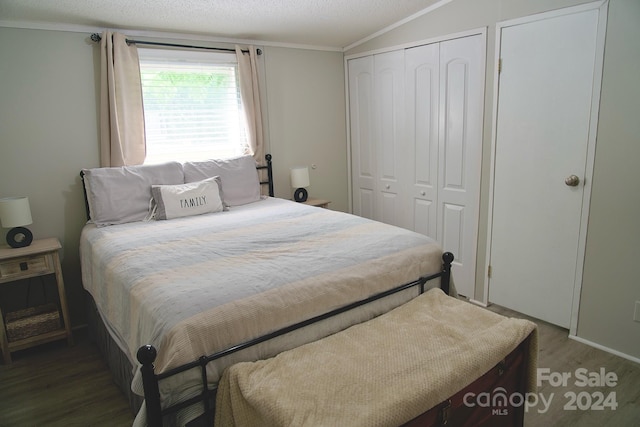 bedroom featuring hardwood / wood-style flooring, a textured ceiling, and ornamental molding