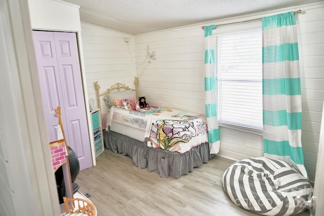 bedroom featuring a textured ceiling, a closet, and light wood-type flooring