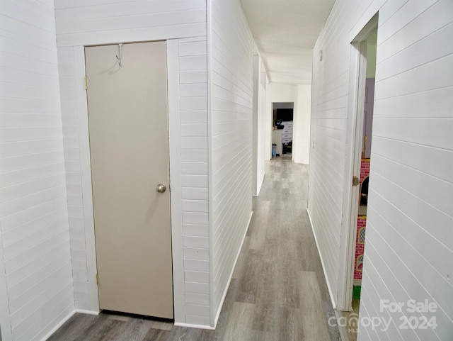 hall with hardwood / wood-style floors and wood walls