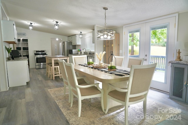 dining space featuring a textured ceiling, a healthy amount of sunlight, and lofted ceiling