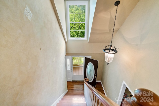 stairs with a towering ceiling and hardwood / wood-style flooring