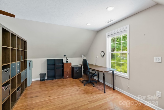 home office with hardwood / wood-style floors, lofted ceiling, and a textured ceiling