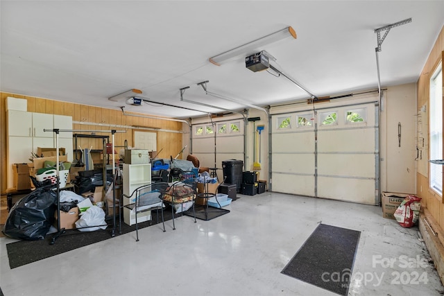 garage with wooden walls and a garage door opener