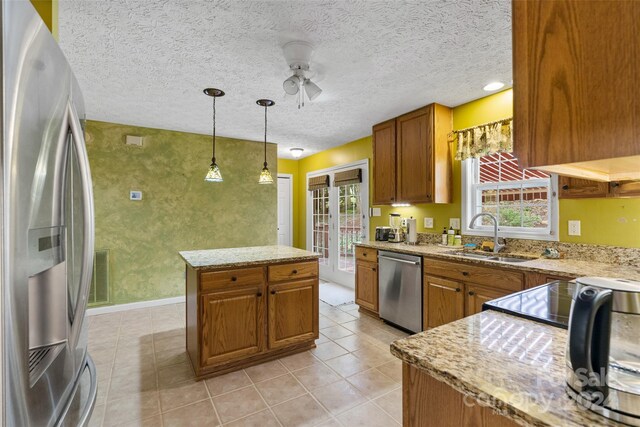 kitchen with pendant lighting, plenty of natural light, sink, and appliances with stainless steel finishes