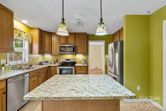 21 Farm Valley Ct, Weaverville, NC 28787 - kitchen featuring stainless steel appliances, a sink, brown cabinetry, a kitchen island, and light stone counters