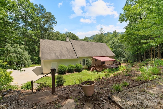 21 Farm Valley Ct, Weaverville, NC 28787 - view of side of property with a wooden deck, a chimney, a lawn, and concrete driveway