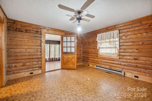 unfurnished room featuring baseboard heating, rustic walls, and a textured ceiling