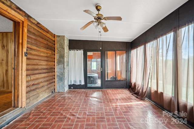 unfurnished sunroom featuring ceiling fan