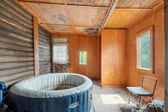 misc room with log walls, a hot tub, and wooden ceiling