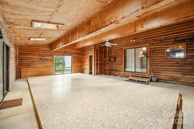 interior space with rustic walls and ceiling fan