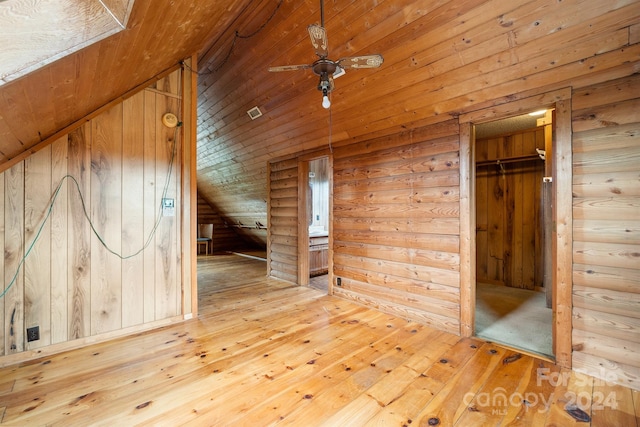 interior space with hardwood / wood-style floors, wooden walls, and vaulted ceiling