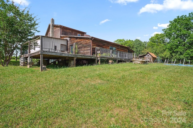 rear view of property with a deck and a lawn