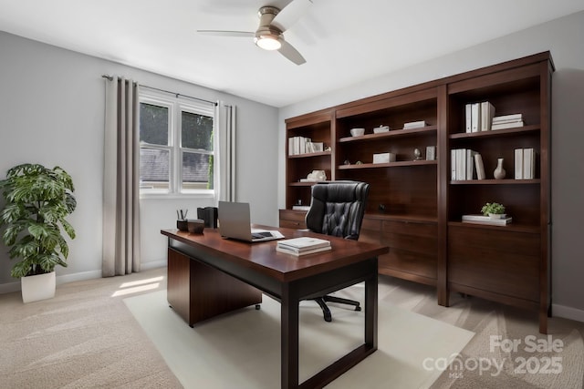 home office with ceiling fan and light carpet