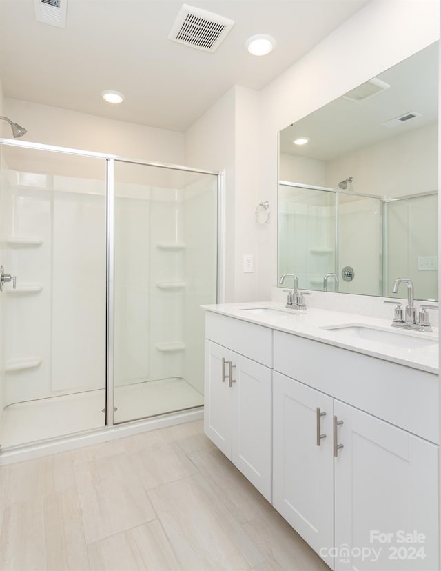 bathroom with vanity and a shower with door