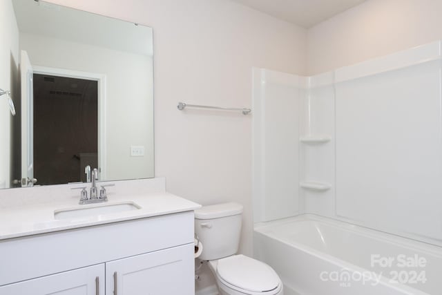 full bathroom featuring washtub / shower combination, vanity, and toilet