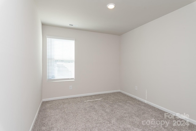 spare room featuring light colored carpet