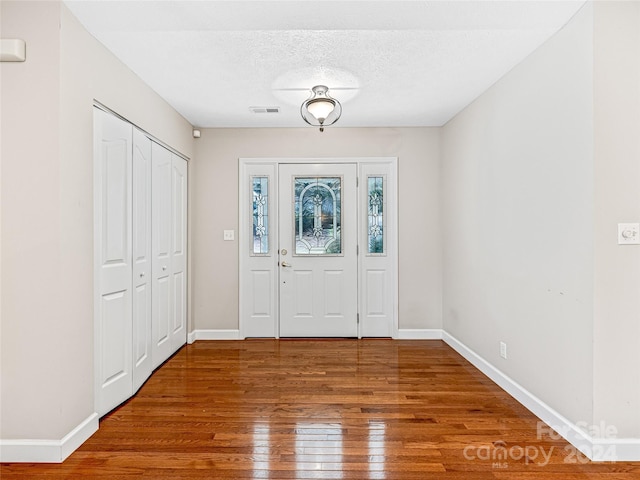 foyer entrance with a textured ceiling and hardwood / wood-style flooring